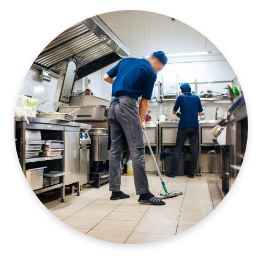 two employees cleaning an industrial kitchen